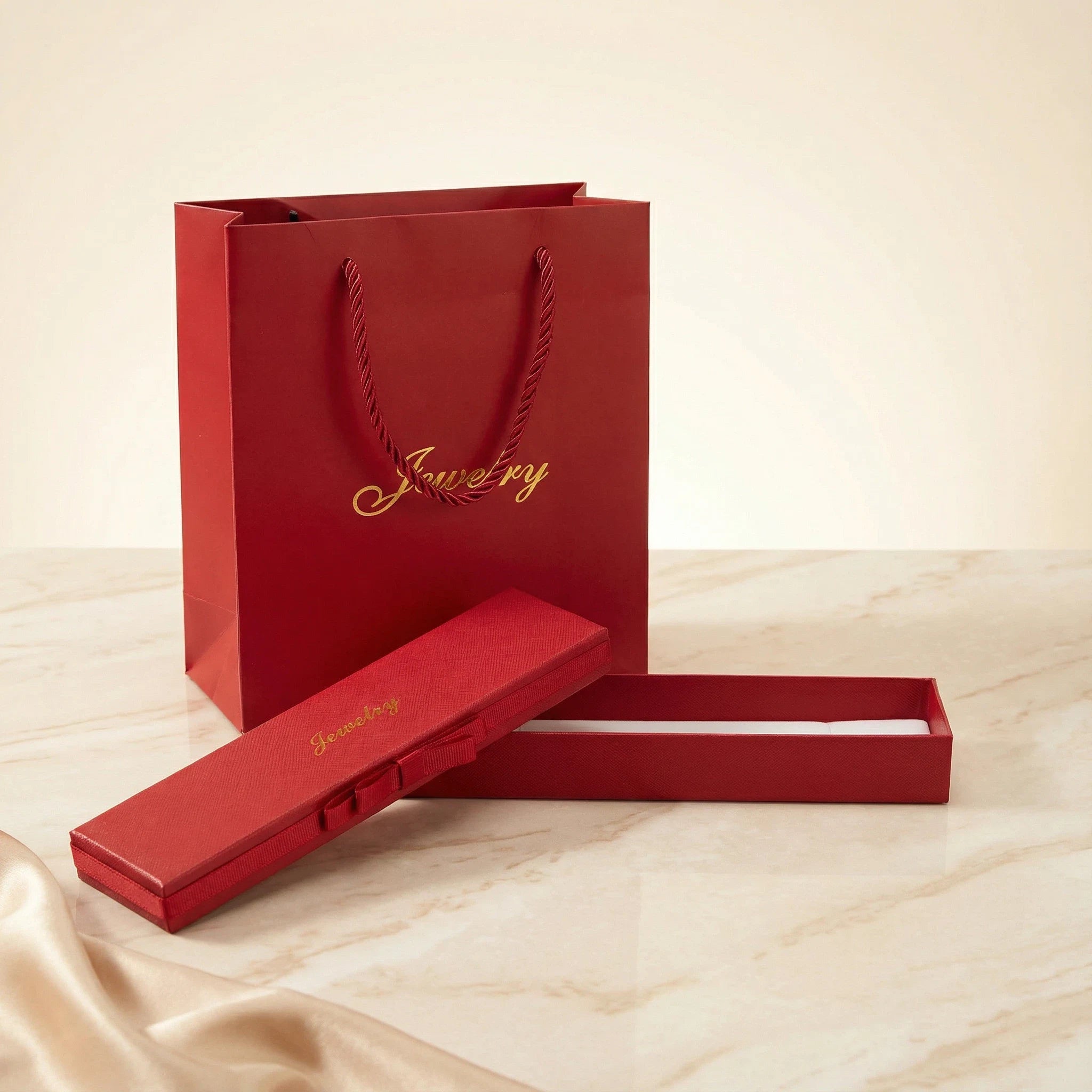 Long red jewelry box shown open with white insert for pendants or bracelets